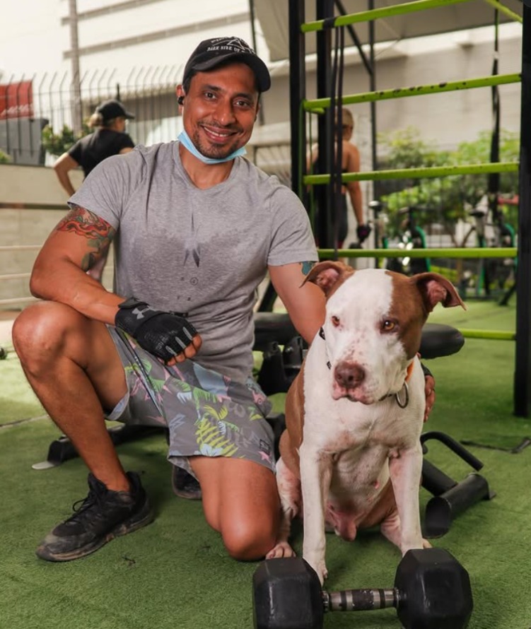 Entrenador de ENERGYM con su mascota en el gimnasio
